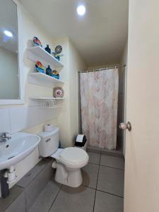 een badkamer met een toilet, een wastafel en een douche bij Los Nogales LS in Lima