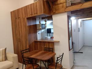 a small kitchen with a wooden table and chairs at Front beach cosy apartment in La Goulette +4 photos