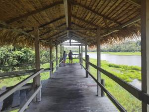 two people walking on a wooden bridge over a river at 10 min do Aeroporto Residencial Romulo 3 in Manaus