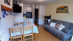 a living room with a table and a couch at Appar T2 3 lits vue montagne terrasse vielle aure in Saint-Lary-Soulan
