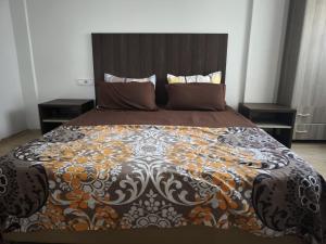 a bed in a bedroom with two night stands at Jolie appartement avec terrasse in Reghaïa +2 photos