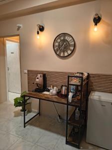 una cucina con tavolo e orologio sul muro di B&B Le Corti a Caserta