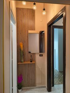 un corridoio con uno specchio, una televisione e dei fiori di B&B Le Corti a Caserta