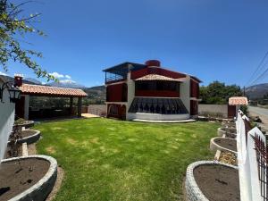 a house with a green yard with a building at Shumaq Guesthouse in Carhuaz
