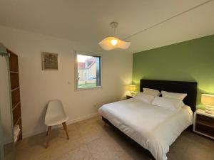 a bedroom with a white bed and a green wall at La Croix Perette in Azay-le-Rideau +23 photos