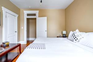 una camera da letto con un grande letto bianco e una scrivania di Jungle House Luxury Stays - Columbus Downtown Short North a Columbus Altre 48 foto