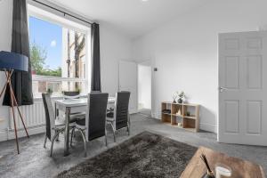 a dining room with a table and chairs and a window at Modern 4BR Parking in Manchester