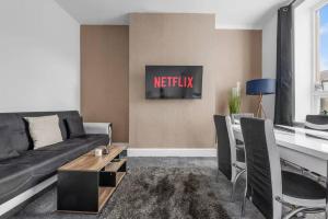 a living room with a couch and a table at Modern 4BR Parking in Manchester
