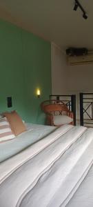 Cama en habitación con pared verde en Caelum House Apartamento, en Rafaela 7 fotos más