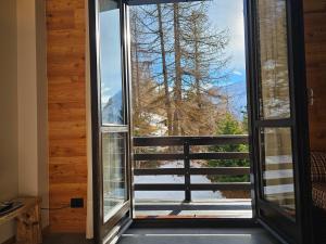una puerta abierta a un balcón con vistas en Cimaboschi, en Sestriere
