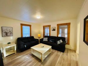 ein Wohnzimmer mit einer schwarzen Couch und einem Tisch in der Unterkunft Home Sweet Home in Laconia + 26 Fotos