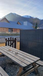 a wooden picnic table in front of a fence at Appar T2 3 lits vue montagne terrasse vielle aure in Saint-Lary-Soulan