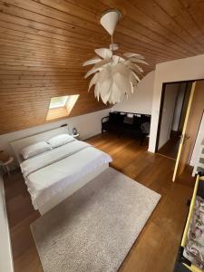 a bedroom with a white bed and a wooden ceiling at Playroom, 2 bdrooms, KRUMLOV 5 min by car, "Stone's throw Apartment" in Kájov