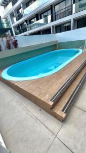 una grande piscina con terrazza in legno intorno di Refúgio à Beira-Mar Cabo Branco João Pessoa a João Pessoa