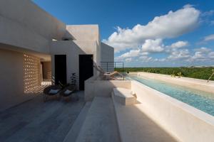 una casa con piscina e due sedie di Oniric Condo Tulum a Tulum