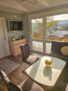 ein Wohnzimmer mit Tisch und großem Fenster in der Unterkunft Ferienhaus Kammblick in Schwarzhausen