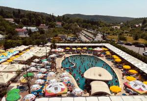 an overhead view of a pool with umbrellas and people at a resort at Pensiunea Duet in Sărata-Monteoru +71 photos
