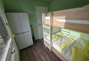 a small bedroom with a bunk bed and a refrigerator at Ferienhaus Kammblick in Schmerbach