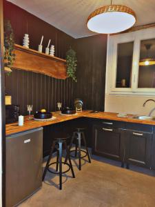 a kitchen with black cabinets and a counter with stools at Esprit Chalet en centre ville Confort et charme in Tours