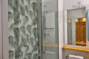 a bathroom with a shower with a green leaf wallpaper at Beachfront Studio in Marigot in Marigot +15 photos