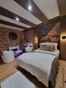 um quarto com uma cama grande e uma parede de pedra em Esprit Chalet en centre ville Confort et charme em Tours
