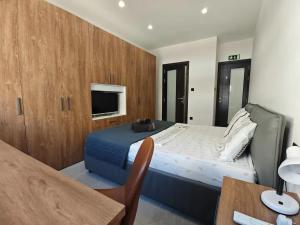 Luxury Qawra Holiday Stay Apartment في خليج سانت بول: غرفة نوم بسرير وتلفزيون وطاولة