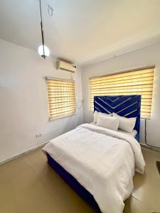 sypialnia z dużym łóżkiem z niebieskim zagłówkiem w obiekcie Crestal Resorts w mieście Magodo