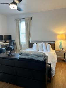 a bedroom with a bed and a dresser with towels on it at Cozy Home away from home! in Miami