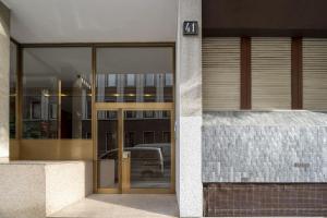 een glazen deur van een gebouw met een parkeerplaats bij Camera privata bagno e balcone Duomo Battaglia Appartamenti in Milaan
