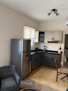 a kitchen with a stainless steel refrigerator and a chair at Mereri downtown apartments, apartment 13C in Oranjestad