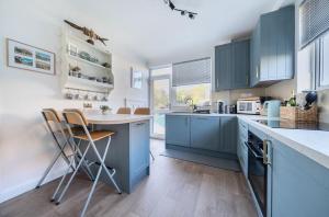 Points في إيست ويترينج: مطبخ مع دواليب زرقاء وطاولة وكراسي
