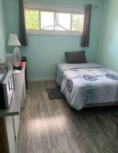 ein Schlafzimmer mit Bett, Schreibtisch und Fenster in der Unterkunft Tight budget room for rent in my singlehouse in Estevan + 14 Fotos