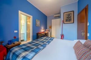 een slaapkamer met blauwe muren en een bed bij Camera privata bagno e balcone Duomo Battaglia Appartamenti in Milaan