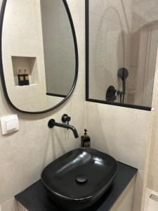Un baño con un lavabo negro y un espejo. en Elite Suite, en Xanthi 12 fotos más