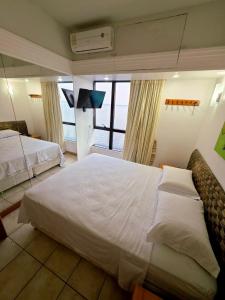 una camera da letto con due letti e una grande finestra di tropical Flat Belissimo a Manaus