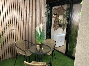 a patio with a table and chairs and a mirror at Thermo'Spa - Gîte Spa Privatif in Calais