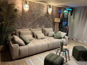 ein Wohnzimmer mit einer Couch mit Kissen darauf in der Unterkunft Thermo'Spa - Gîte Spa Privatif in Calais