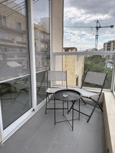 Luxury Qawra Holiday Stay Apartment في خليج سانت بول: بلكونه عليها طاوله وكرسي