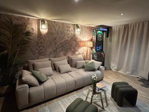 a living room with a couch and a wall at Thermo'Spa - Gîte Spa Privatif in Calais