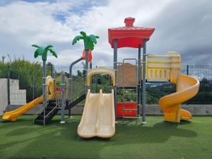 plac zabaw z różnymi rodzajami zjeżdżalni na trawniku w obiekcie Bambú Luxury Stay-10 min from Airport w mieście Heredia