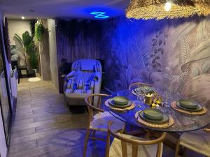 ein lila Esszimmer mit einem Tisch und Stühlen in der Unterkunft Thermo'Spa - Gîte Spa Privatif in Calais