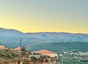a building on a hill with mountains in the background at 603 Apartments in Baddah