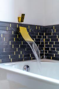 un flusso d'acqua che esce da una vasca da bagno di Jungle House Luxury Stays - Columbus Downtown Short North a Columbus