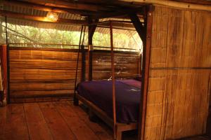 a bedroom with a bed in a wooden cabin at Cabaña Corazon Mazunte in Mazunte
