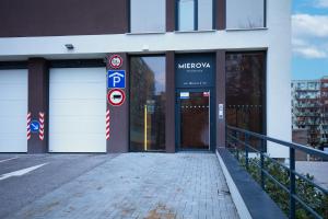 Apartmán Mierova في براتيسلافا: مبنى به بابان أبيضان للمرآب ولافتة لوقوف السيارات