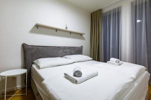 Apartmán Mierova في براتيسلافا: غرفة نوم بها سرير مع مناشف عليه