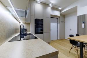 Apartmán Mierova في براتيسلافا: مطبخ وغرفة طعام مع طاولة وكراسي