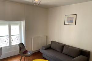 a living room with a couch and a window at Studio - Centre-Ville in Chalon-sur-Saône