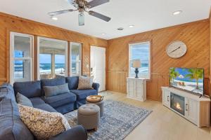 Una sala de estar con un sofá azul y un televisor en 7144 - Dolphin Lookout ( formerly Sabah Vacations), en Wanchese