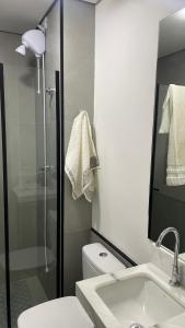 a bathroom with a shower and a toilet and a sink at Flat Apartamento Av Esmeralda em Marília in Marília +14 photos